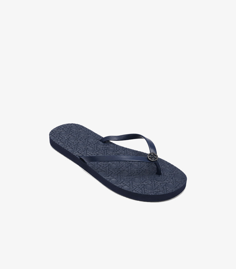 Angled view of Tory Burch women’s navy logo flip-flop with geometric textured footbed