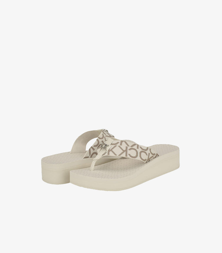Pair of Calvin Klein monogram platform flip-flop sandals in an angled view