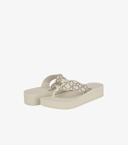 Pair of Calvin Klein monogram platform flip-flop sandals in an angled view