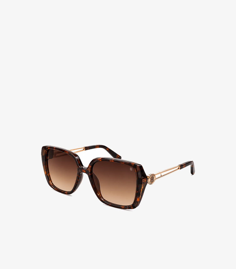 Angled view of Tommy Hilfiger women’s oversized tortoiseshell square sunglasses with brown gradient lenses and gold-tone temples