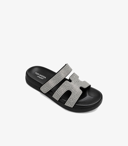 Angled view of Top Moda black rhinestone platform slides showing the cushioned footbed and cut-out front strap