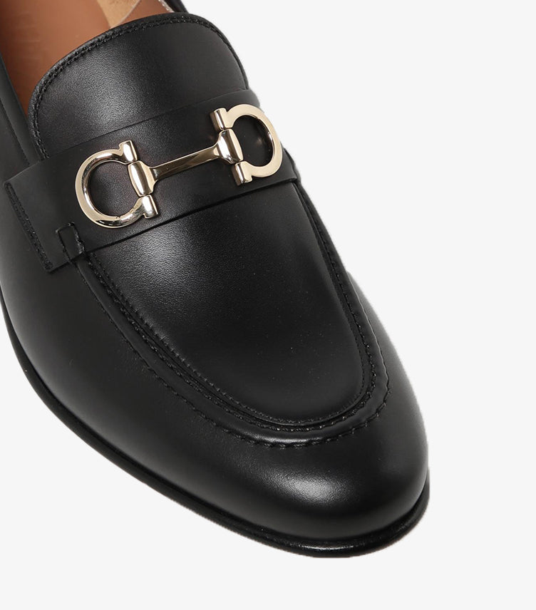 Close-up of Ferragamo black leather loafer with gold-tone Gancini bit and moccasin stitching