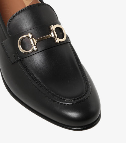 Close-up of Ferragamo black leather loafer with gold-tone Gancini bit and moccasin stitching