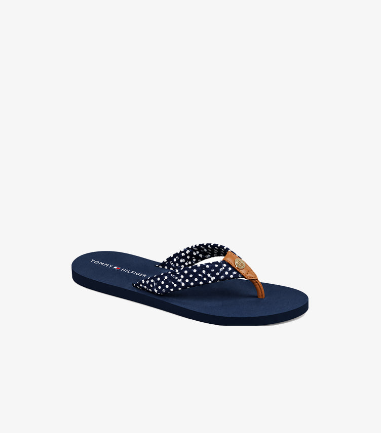 Angled view of Tommy Hilfiger polka dot flip-flop sandal with thong strap and TH emblem hardware