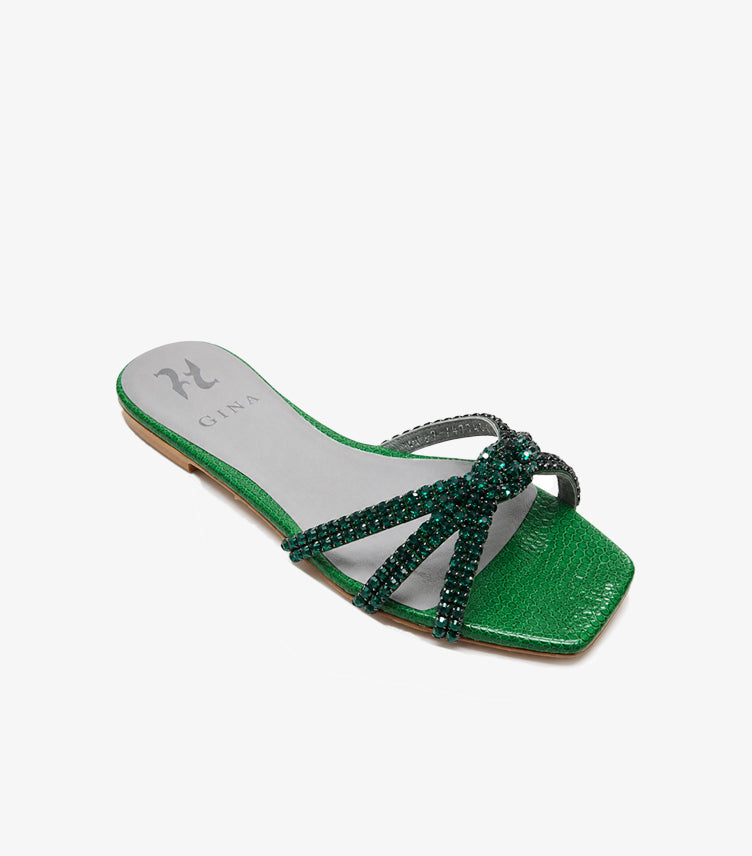 Angled view of GINA emerald green slip-on sandals with crystal crossover straps