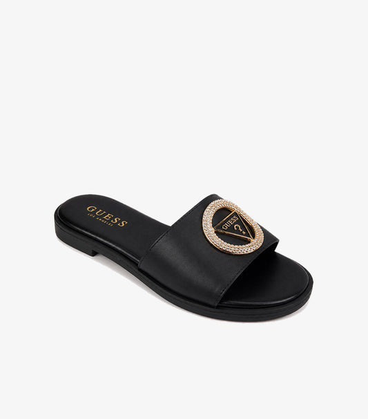 GUESS Los Angeles black smooth leather wide-strap flat slide sandal angled view showing crystal pave triangle logo gold medallion