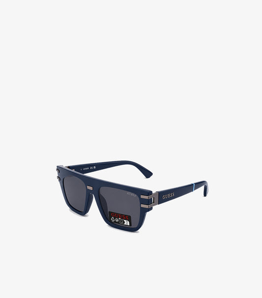 GUESS men's navy blue square flat-top sunglasses angled view showing smoke grey lenses gunmetal hardware and blue temple tip accent