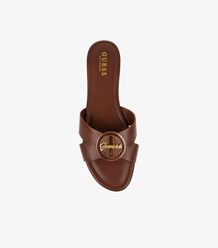 GUESS brown cross-strap flat slides top-down view showing gold GUESS script medallion and GUESS LOS ANGELES branded insole
