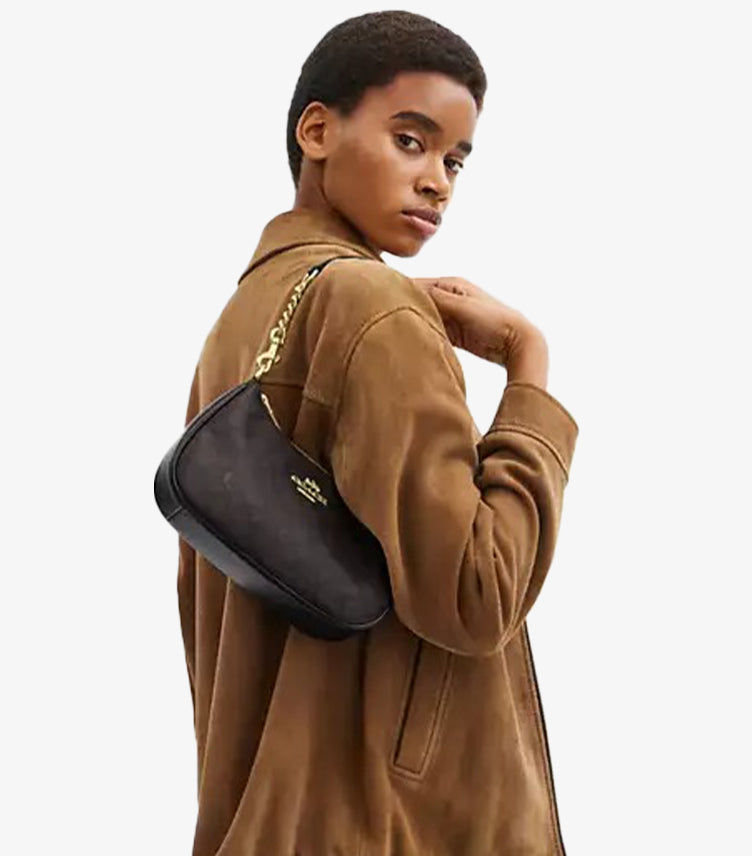Model wearing Coach Teri Gold Walnut Black Signature canvas bag on shoulder