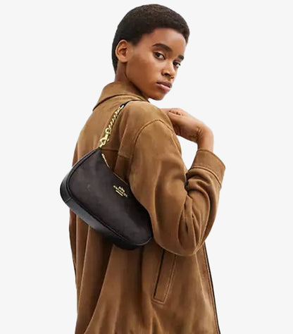 Model wearing Coach Teri Gold Walnut Black Signature canvas bag on shoulder