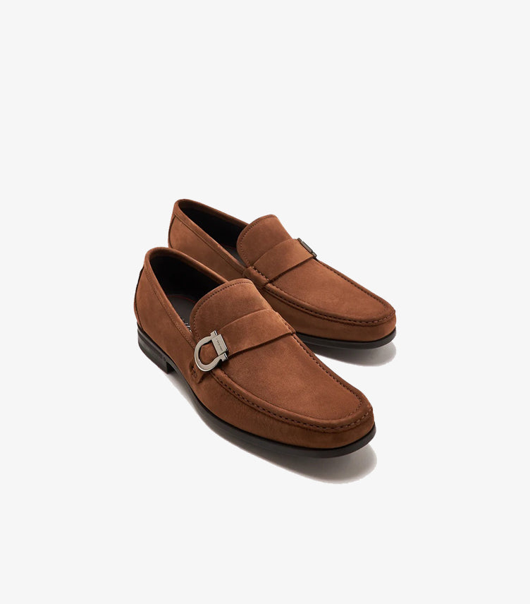 Angled pair of Ferragamo brown suede loafers featuring silver-tone Gancini hardware and moc-toe stitching
