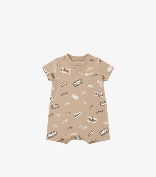 Front product view of Nike baby beige logo print romper with a round neck, short sleeves and short legs