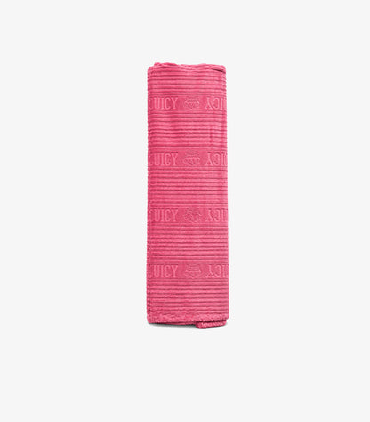 Folded pink Juicy Couture plush throw blanket featuring ribbed texture and repeating embossed branding