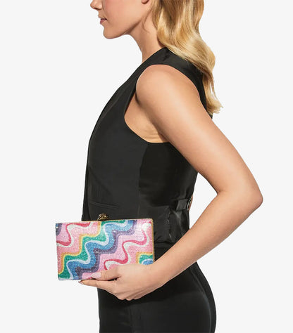 Model holding Kurt Geiger crystal-embellished rectangular clutch bag with abstract wave detailing