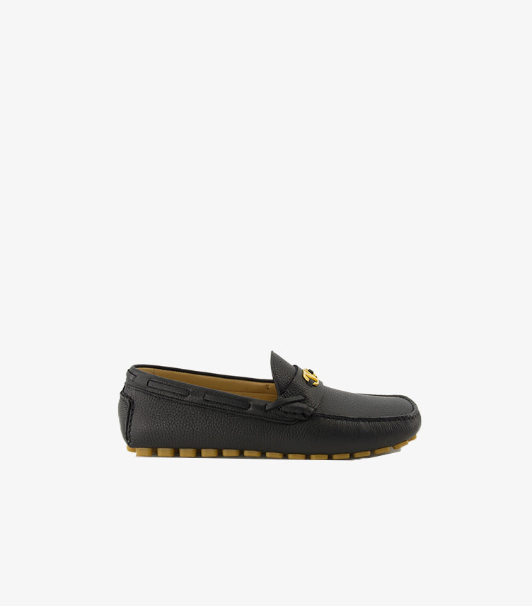 Valentino Garavani men's black leather driving loafer side profile with tan rubber studded sole