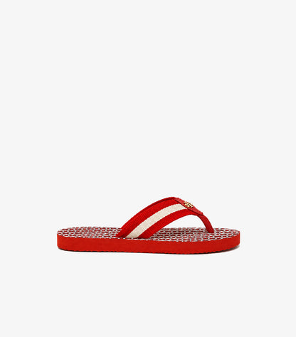 Side view of Tory Burch red flat flip-flop featuring a striped fabric thong strap