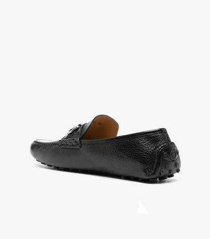 Ferragamo black pebbled leather driver loafer back view showing signature circular rubber pebble heel pad and driving sole construction
