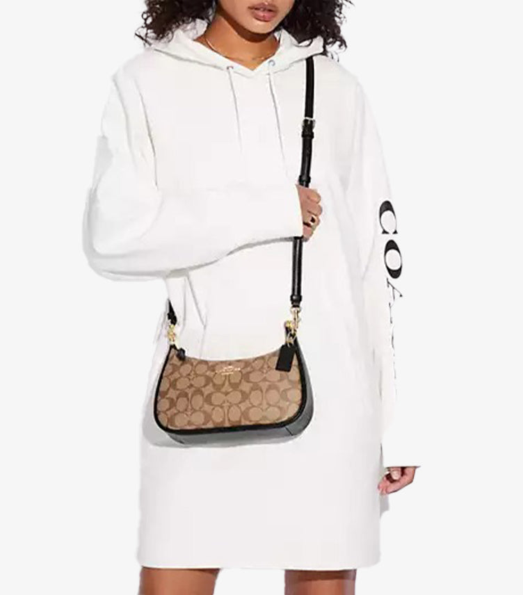 Model wearing Coach Teri Signature canvas bag as crossbody with 22.75 inch strap drop